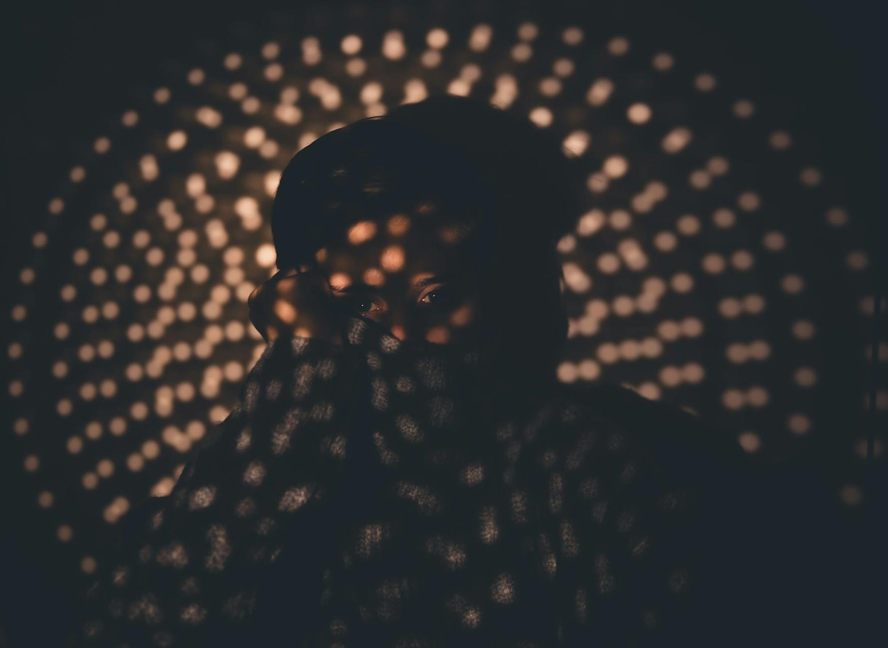 Silhouette of a person in a yoga pose against a dark, moody background.